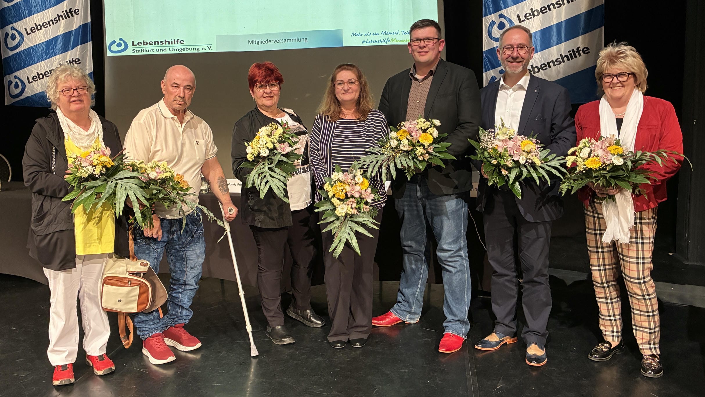 Vorstandsmitglieder mit Blumensträußen